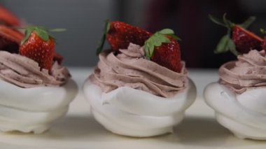 Krem ve çilek ile Pavlova Tatlılar. Kamera slaytı sola