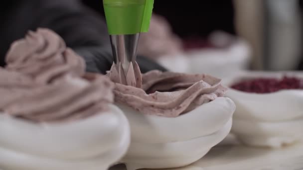 Decoreren van de woestijn van Pavlova met crème met behulp van koken tas in slow motion — Stockvideo