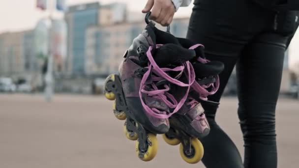 Menina bonita com patins. Caminhada de mulher jovem com patins — Vídeo de Stock