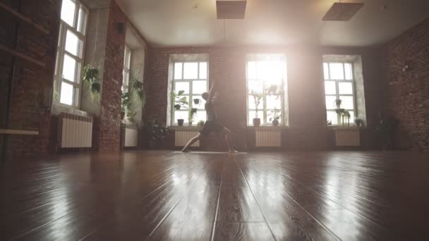 男子练习瑜伽姿势在工作室与砖墙和阳光 有吸引力的男性在健身房做瑜伽姿势在慢动作 健身和健康的生活方式概念与复制空间 — 图库视频影像
