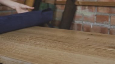 Deri ustasının yakın çekim stüdyoda deri unrolls. Masada deri rulo. Deri cüzdan üretim süreci