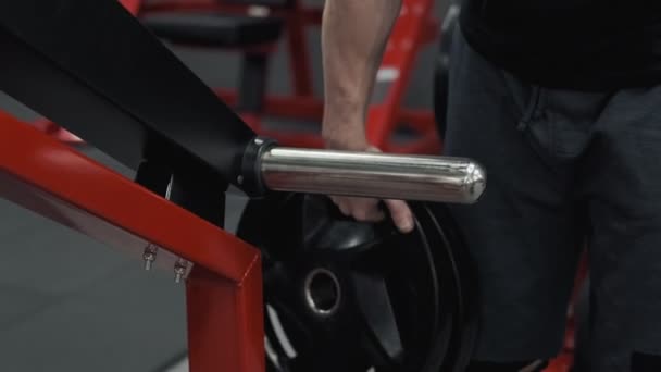 Close-up van bodybuilder voorbereiden om oefeningen te doen met barbell in de sportschool — Stockvideo