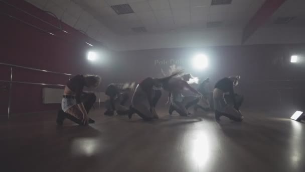 Девушки наслаждаются танцхоллом движется в темную студию с дымом и освещением — стоковое видео