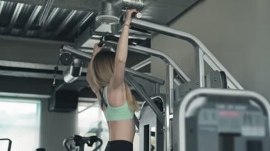 Sarışın kadın spor salonunda yukarı çekiyor. Spor sağlıklı yaşam tarzı. Fitness kız pull up yapıyor. Spor salonundaki sportif kadın. Atletik sportif bir kadın. Orta atış