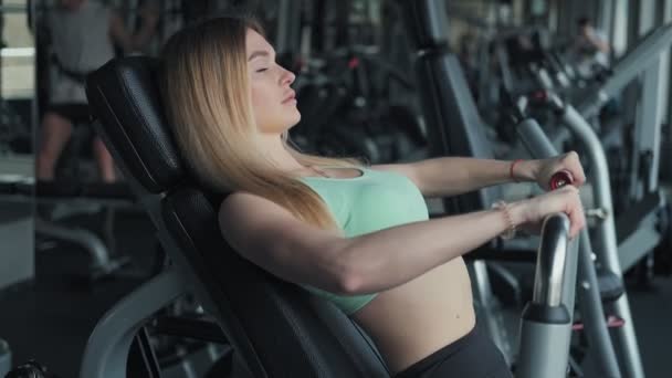 ジムでエクササイズをする美しい女性 体重で運動をしているブロンドの女性の肖像画 スローモーションでジムで運動するフィットネスの女の子のミディアムショット — ストック動画