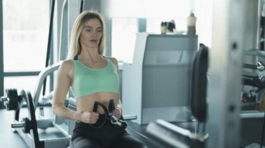 Kilo ile egzersiz yapan sarışın kadın Portresi. Spor salonunda çalışan genç bir kadın. Yavaş çekimde spor salonunda egzersiz fitness kız Orta çekim.