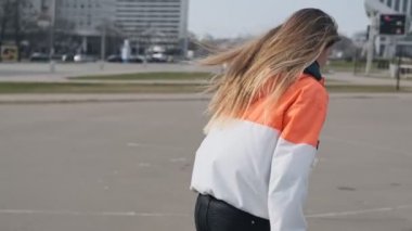Patenli kızın arka görünümü. Paten kullanan kız. Sokakta paten sürme genç kadın
