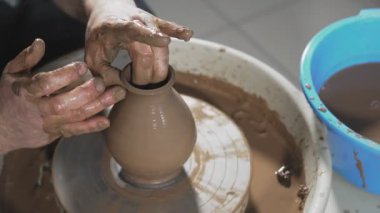 Eller yavaşça kilden doğru şekilli el yapımı oluşturun. Çömlekçi yakın çanak çömlek tekerleği veya çömlekçi torna iplik çömlek üzerinde ürün oluşturur