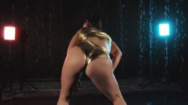 Yavaş çekimde yağmur, kırmızı ve mavi ışık ile karanlık stüdyoda dans seksi twerk kafkas kız. Twerking kadın Orta atış