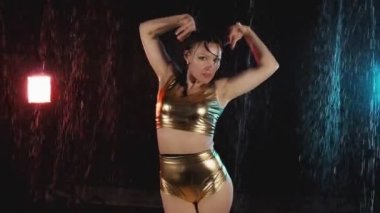 Esmer kadın siyah arka plan üzerinde stüdyoda dans. Sıcak kız ustaca dans ediyor. Su yla dolu stüdyo. Orta atış