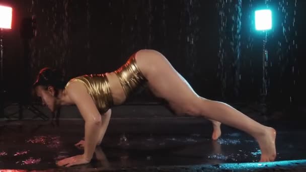性感的黑发女孩扭动她的屁边躺在地板上 穿短裤的女孩在雨中在演播室里跳舞 女孩熟练地跳舞 Twerk — 图库视频影像