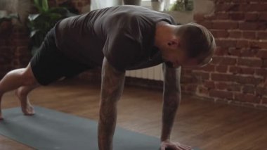Adam uygulama yoga tuğla duvar ile stüdyoda poz. Spor salonunda yoga pozu yapan çekici erkek. Fitness ve sağlıklı yaşam tarzı kavramı