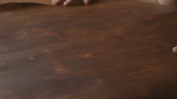 スローモーションでテーブルの上に革の大きな部分に触れる革マスター 女性の手のクローズアップショット — ストック動画