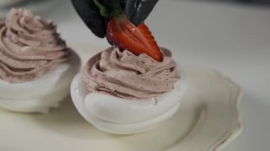 Çilek ile Dekorasyon pasta kapatın. Pavlova lezzetli tatlılar üzerinde tereyağı krema. Ev fırın konsepti
