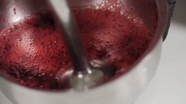 Şekerlemeci kiraz ile kaseye elektro blender koyuyor. O yavaş çekimde Pavlova tatlı pişirmek için çilek freze olduğunu. Adım adım