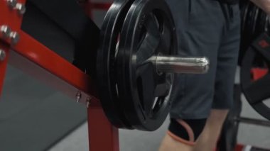 Vücut geliştirmeci yakın spor salonunda barbell ile egzersizler yapmaya hazırlayın, yavaş hareket elinde halter plaka tutmak