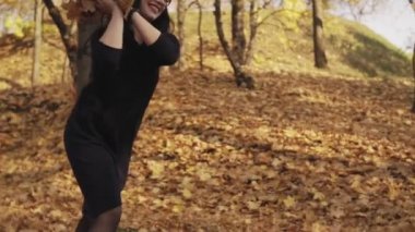 Sonbahar parkında eğlenen aile. Anne ve kız akçaağaç yapraklarıyla oynuyorlar. Anne ve kızı sonbahar yaprakları ile oynamak. Orta, eğim atış