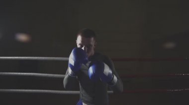 Sporcu muay thai boksör boks kafesinde slomo kameraya bakarak mücadele