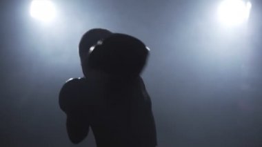 Düşük ışık spor salonunda Kickboxer eğitim. Kamerada sporcu boksu