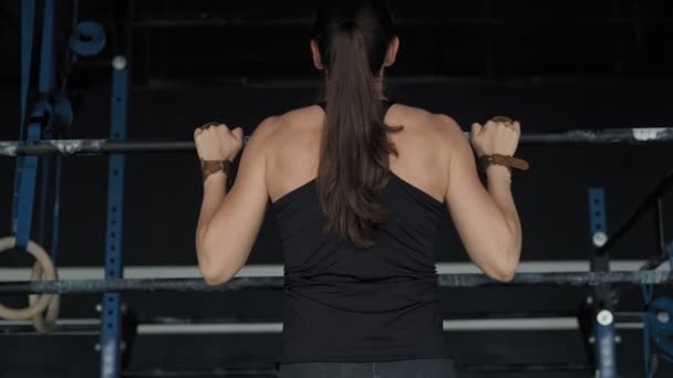 Молодая женщина тренировки подтягивания упражнения наслаждаясь интенсивной фитнес-тренировки в тренажерном зале — стоковое видео