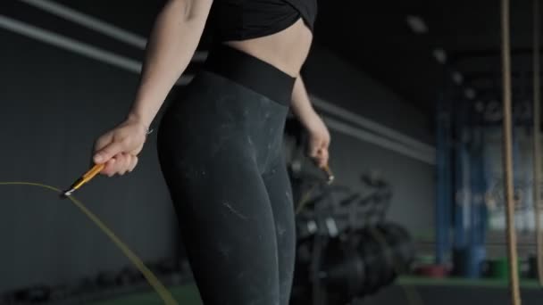 Primer plano de la mujer deportiva con buena figura salta cuerda en el gimnasio. Ejercicios mujer — Vídeos de Stock