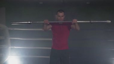 Yavaş çekimde dumanlı stüdyoda halter ile Figher eğitim. Yavaş çekimde düşük ışık spor salonunda Kickboxer eğitim. Koyu arka planda siluet