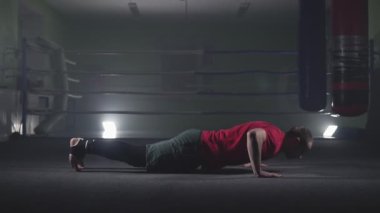 Profesyonel atlet karanlık dumanlı spor salonunda şınav yapıyor. Boksör eğitimi. Yavaş çekimde spor konsepti