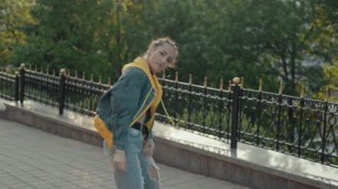 Güzel yetenekli kadın serbest hip hop performans merdivenlerde yavaş hareket dans zevk. Açık havada pigtails ile kot çekici dans kız. Orta atış