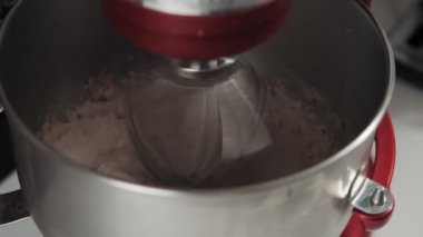 Hamuru mikserle karıştırıyoruz. Kırmızı mikser ile krem hamur pişirme. Kek ve diğer pişirme için Hamur. Çalışan kırmızı mikser ayakta yakın çekim görünümü
