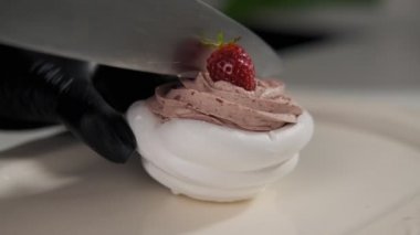 Yavaş çekimde krem ve çilek ile Pavlova tatlılar kesme fırıncı yakın. Bıçak kesme pastası