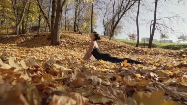 Beyaz kadın fitness modeli güneşli sabah çalışma. Güzel ince kadın sonbahar parkta yoga. Spor kadın fitness eğitim açık önce vücut ısınma.