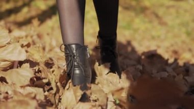 Kadın bacak tekme ve yavaş hareket sonbahar yaprakları atma yakın. Kadın bacaklar sonbahar sarı düşmüş Leafs tekme