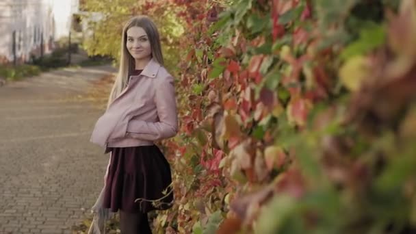 Bájos Nézi Kamerát Őszi Levelek Háttérben Közepes Shot Rózsaszín Kabát — Stock videók