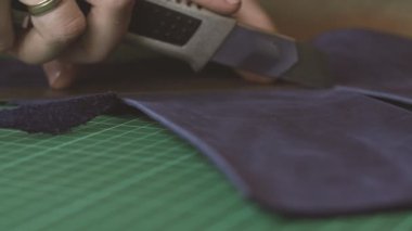 Mavi deri kesme ustanın elleri. Kadın esnaf elleriyle yakın. Master atölye cüzdan yapar.