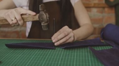 Deri profesyonel işçi deri delikler yapar. Üretim deri cüzdan el yapımı süreci. Master atölye cüzdan yapar.