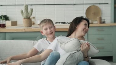 Mutlu anne yatmadan oyun ve sarılmak oğlu ile zaman harcamak. Güzel anne ve oğul sarılmak at yatak ile yastıklar
