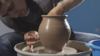 Potter, çömlekçi Torna iplik çömlek üzerinde ürün yaratır. Eller yavaşça yavaş hareket kil doğru şekilli el yapımı oluşturun. Step adım
