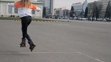 Paten sürme kız. Sokakta paten sürme genç bir kadın. Paten üzerinde çekici kadın