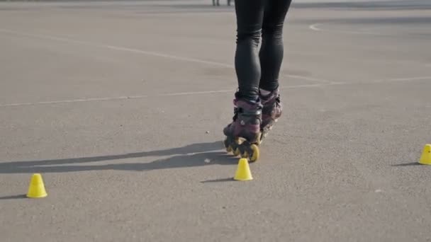 双腿的特写骑在溜冰鞋和旋转在慢动作 女孩驾驶溜冰鞋 — 图库视频影像