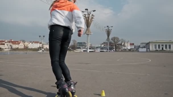 年轻的时尚女孩骑溜冰鞋在慢动作 女孩在公园滑轮 — 图库视频影像
