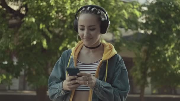 Frau hört Musik und tippt Bildschirm des Telefons. Frauen genießen Musik — Stockvideo