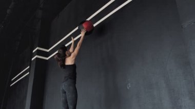 Esmer kadın performans duvar topu egzersiz. arka görünüm. Orta çekim