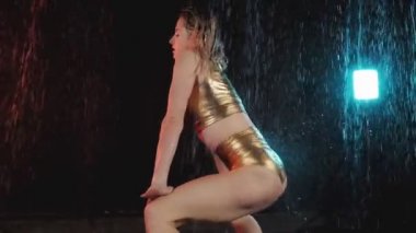 Sıcak kız usta dans twerk. Su ile stüdyo. Siyah arka planda stüdyoda twerk dans sarışın kız. Orta çekim