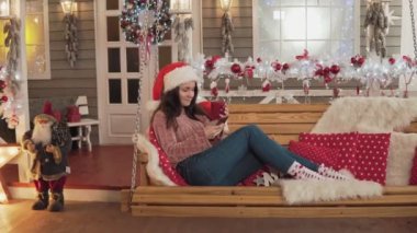 Noel Baba şapkasındaki çekici esmer kadın Noel'de birini telefonla arayıp kahve içerken selamlıyor. Noel ağacının yanında bankta oturan güzel bir kız telefonda mesaj atıyor. Tam uzunlukta çekim