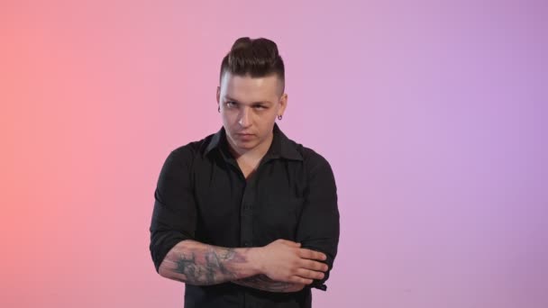 スタジオの背景に赤と紫のライトで歌うタトゥーを持つ若者のミディアムショット — ストック動画