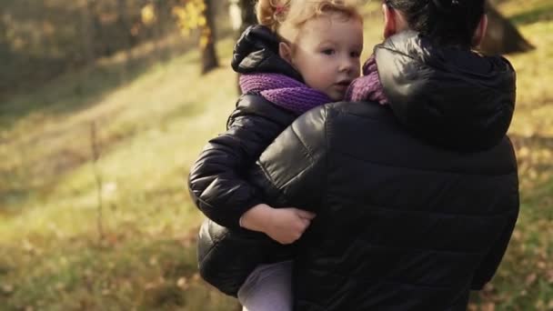 Маленькая Дочь Руках Матери Осеннем Парке Дочь Молодая Мать Гуляют — стоковое видео