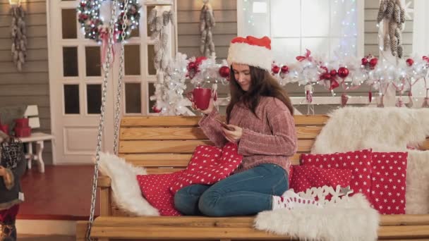 Attraktive Brünette Frau Mit Weihnachtsmütze Die Telefon Und Kaffee Jemanden — Stockvideo