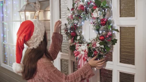 Attractive Girl Santa Hat Sweater Hanging Christmas Wreath Balls White — Stock Video