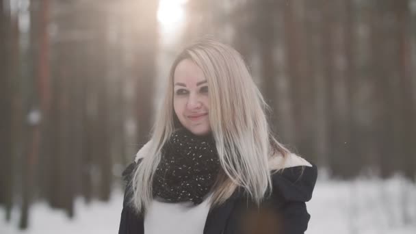 Portrait de jeune belle fille regardant la caméra. Femme blonde dans le parc d'hiver — Video