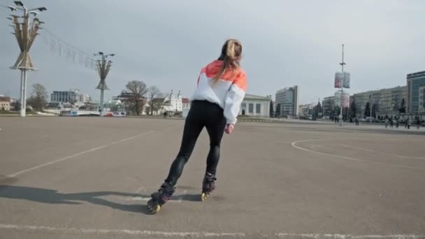 Вид сзади девушки на роликовых коньках. Привлекательная женщина катается на роликах — стоковое видео